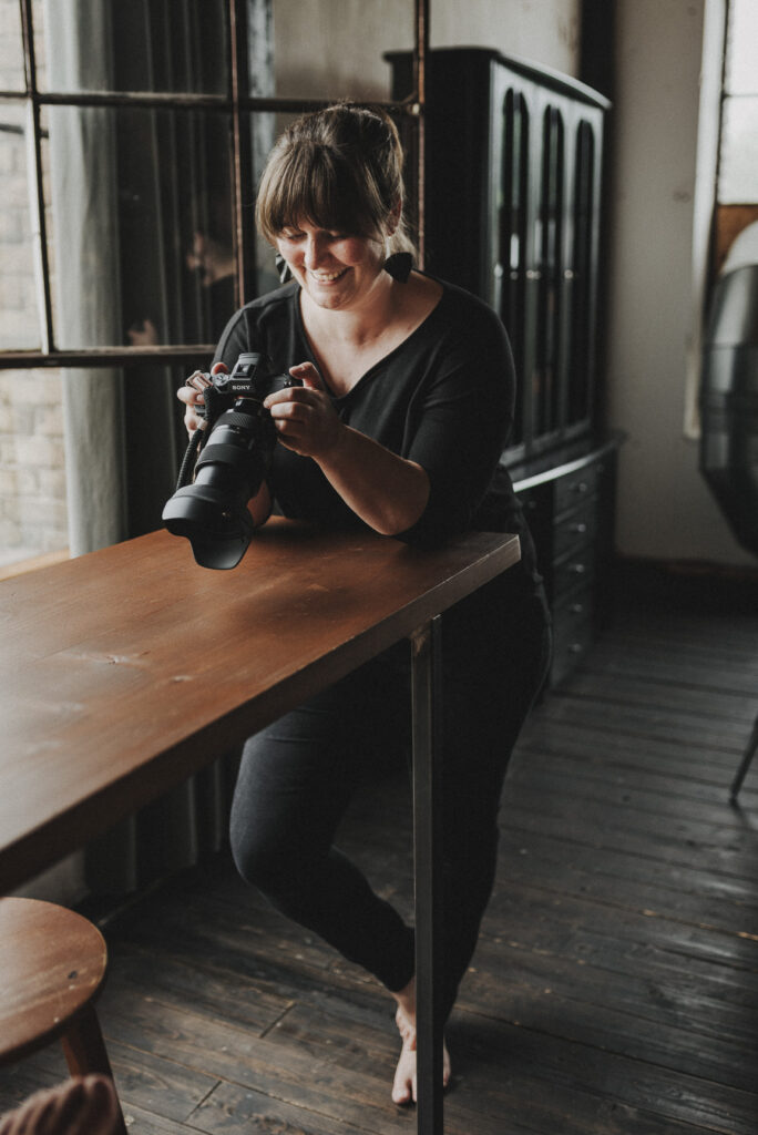 Fotografin Manuela Vogeler lächelt beim Blick auf ihre Kamera